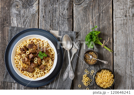 pasta rings topped with braised meat in bowl pasta rings topped with braised meat in bowl 120646241