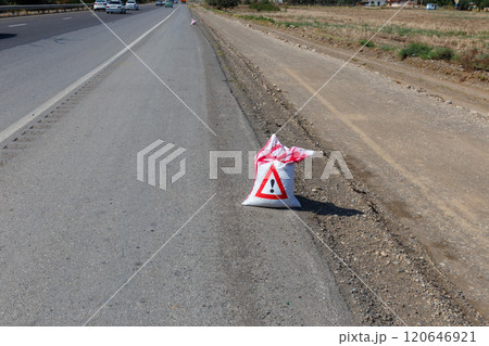 Warning sign indicating road work alongside a busy highway in a rural area Warning sign indicating road work alongside a busy highway in a rural area 120646921