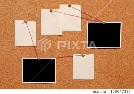 Blank paper notes and an empty photo are pinned to a cork board. The concept of detective investigation. 120647355