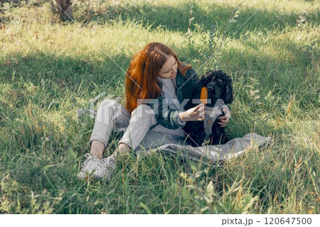 cooling joy of popsicles with pets, summer campaigns more inclusive and fun, red-haired woman, dog in park with ice cream 120647500