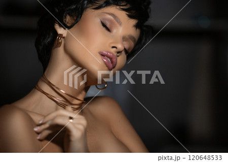 Close-up portrait of a sensual Caucasian young woman with closed eyes touching her skin. Skin care concept. Enjoy. Photo with copy space over dark background. 120648533