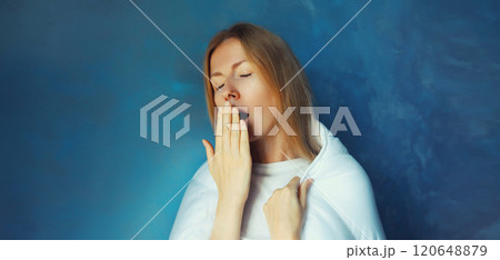 Sleepy lazy young woman yawns wakes up after sleep in blanket in morning at home 120648879