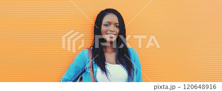 Portrait of happy stylish young african woman in casual clothing, glasses posing in the city Portrait of happy stylish young african woman in casual clothing, glasses posing in the city 120648916