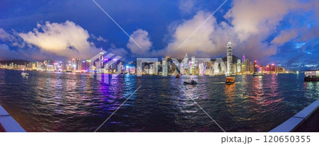 Panoramic nighttime view of illuminated Hong Kong skyline reflected in the water with vibrant city lights Panoramic nighttime view of illuminated Hong Kong skyline reflected in the water with vibrant city lights 120650355