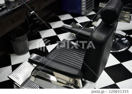 Stylish black salon chair in a modern barbershop with checkered floor design Stylish black salon chair in a modern barbershop with checkered floor design 120651355