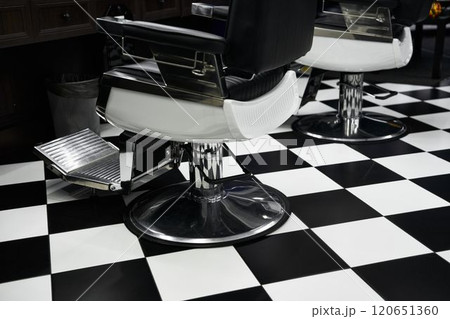 Classic barber shop interior featuring black and white checkerboard floor design 120651360