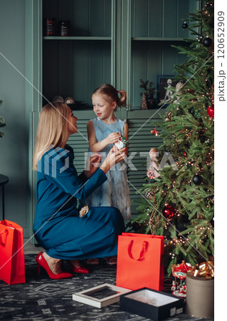 Little girl and her mom on Christmas morning at 120652909
