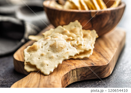 A crispy salted crackers on cutting board on black table. 120654410
