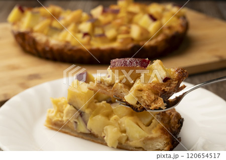 焼きたてのさつま芋とりんごのキッシュをフォークで持ち上げる 120654517