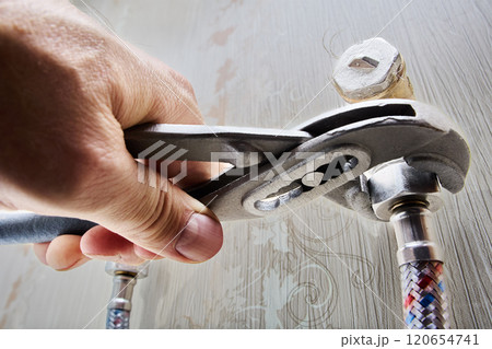 Flexible braided connecting hose is connected to elbow fitting with fastening nut is tightened using adjustable wrench pliers. 120654741