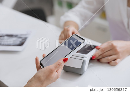 Contactless smartphone payment at a clinic reception desk for a seamless transaction 120656237