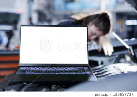 Mockup laptop with blurry background of repairman changing old car brake fluid with new one in repair shop. Isolated screen device and adept garage worker using equipment to do automobile checkup 120657737
