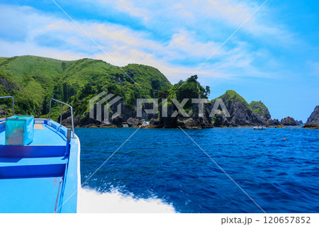 ヒリゾ浜渡船に乗って出港するスキンダイバー、シュノーケラー。 青い海と無人島の大根島、岩礁が見える。 ヒリゾ浜渡船に乗って出港するスキンダイバー、シュノーケラー。 青い海と無人島の大根島、岩礁が見える。 120657852