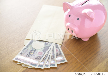 ブタの貯金箱と封筒に入れられたお札(新紙幣) ブタの貯金箱と封筒に入れられたお札(新紙幣) 120658117