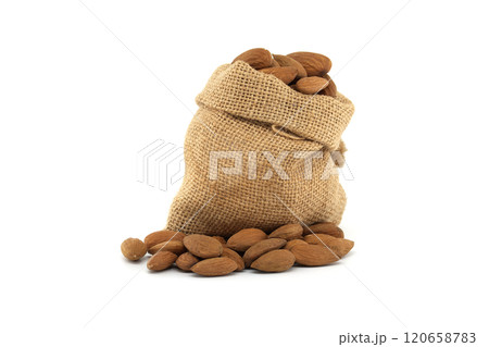 Rustic burlap sack overflowing with fresh almonds isolated on white background 120658783