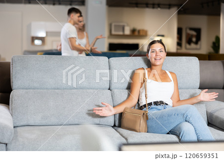 Young woman chooses sofa in store Young woman chooses sofa in store 120659351