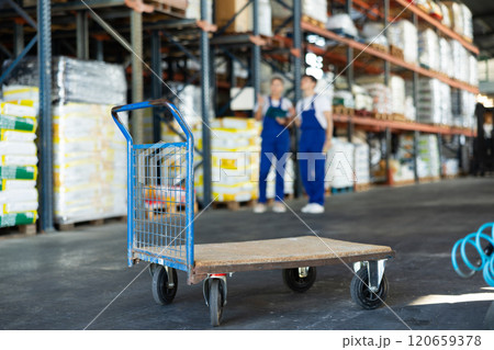Trolley stands against backdrop of warehouse Trolley stands against backdrop of warehouse 120659378