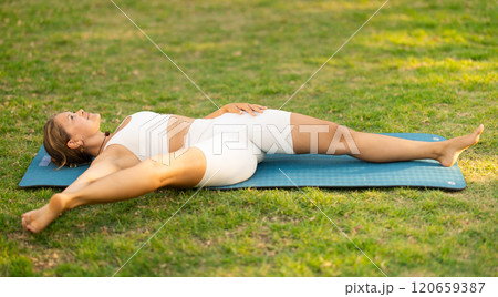 Sporty girl performing yoga asanas on green meadow in summer Sporty girl performing yoga asanas on green meadow in summer 120659387