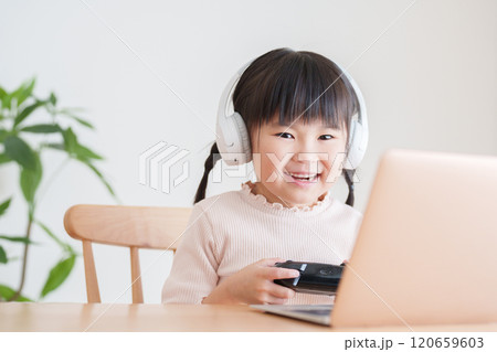 ノートパソコンでテレビゲームをする子供 120659603