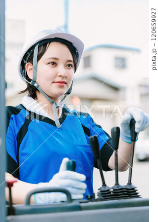 フォークリフトを操縦するヘルメット姿の女性 120659927