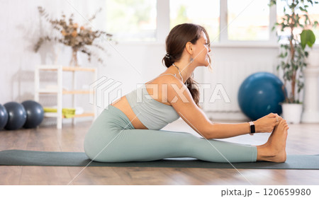 Experienced girl fitness club teacher performs paschimottanasana Experienced girl fitness club teacher performs paschimottanasana 120659980