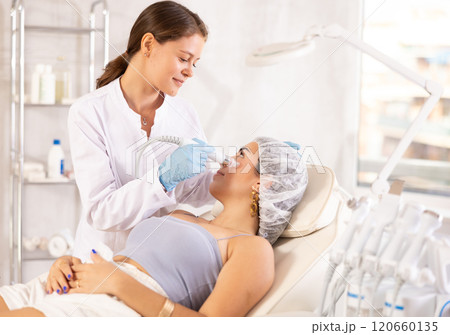 European doctor making Beauty procedure to brunette girl (skin cleaning) 120660135