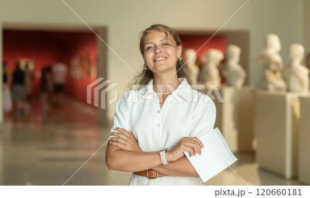Woman with sheet piece of paper in hands view sculpture in museum hall 120660181
