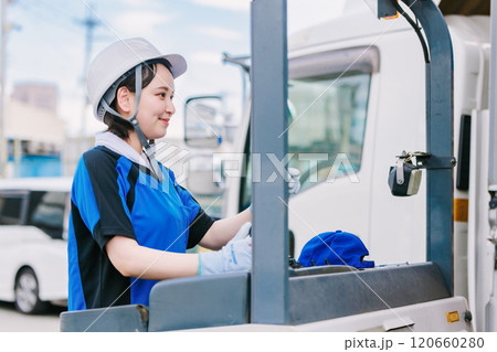 フォークリフトを操縦するヘルメット姿の女性 フォークリフトを操縦するヘルメット姿の女性 120660280