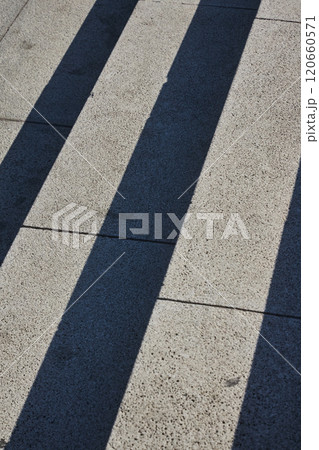 Concrete steps of a staircase made of gray blocks. Diagonal lines, hard shadows 120660571