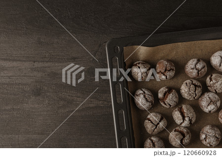 Appetizing crinkle cookies, on parchment, on a dark background. 120660928