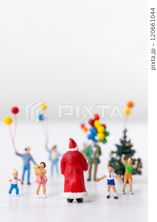 Miniature Santa Claus holding a gift surrounded by children and colorful balloons Miniature Santa Claus holding a gift surrounded by children and colorful balloons 120661044