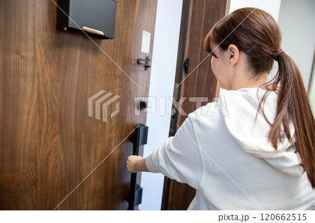 玄関ドアを開ける日本人女性の後ろ姿 120662515
