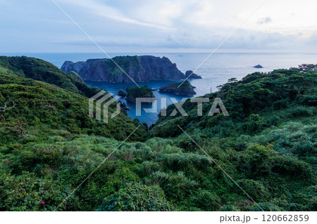 岬の展望台から見下ろす美しい夕暮れのヒリゾ浜の紺碧の海。 大根島などの無人島や小島、地磯が見える。 120662859