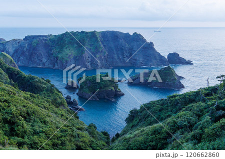 岬の展望台から見下ろす美しい夕暮れのヒリゾ浜の紺碧の海。 大根島などの無人島や小島、地磯が見える。 120662860