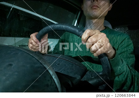 夜、雨の中の車の運転をする中年男性 120663844