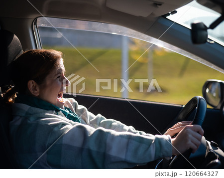 Caucasian woman gets scared while driving with her hands out in front of her before a collision. Caucasian woman gets scared while driving with her hands out in front of her before a collision. 120664327