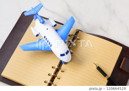 飛行機と、システム手帳で、次の長期休暇に旅行を計画しているイメージ 120664529