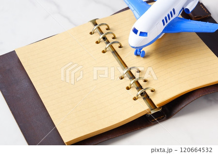 飛行機と、システム手帳で、次の長期休暇に旅行を計画しているイメージ 120664532