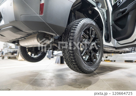 Car on a lift during tire change.  120664725