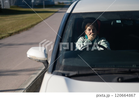 Caucasian woman cries while driving. Caucasian woman cries while driving. 120664867