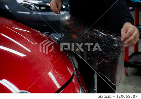 The process of applying protective vinyl film to car headlights in detailing. The process of applying protective vinyl film to car headlights in detailing. 120665387