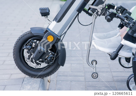 A faceless woman in a wheelchair with an assistive device for manual control. Electric handbike. A faceless woman in a wheelchair with an assistive device for manual control. Electric handbike. 120665611