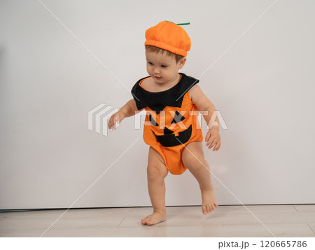 Cute Caucasian boy in pumpkin costume for Halloween.  120665786