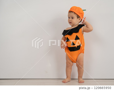 Cute Caucasian boy in pumpkin costume for Halloween.  120665950