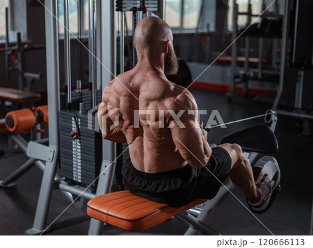 Caucasian man doing rowing exercises on a rowing machine.  120666113