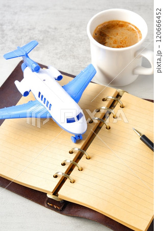 ミルク入りのコーヒー、カフェ・ラテと飛行機、リング式のシステム手帳で、旅行を計画しているイメージ 120666452