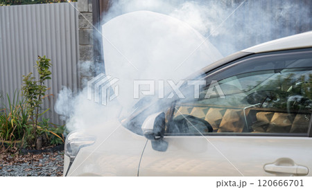 Smoke is coming from under the hood of the car.  120666701