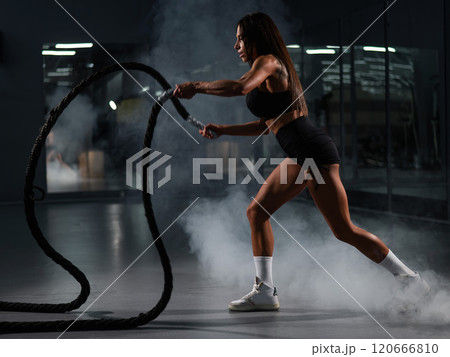 Caucasian woman doing exercise with ropes. Circuit training in the gym. Caucasian woman doing exercise with ropes. Circuit training in the gym. 120666810