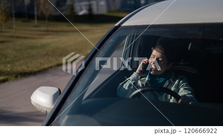 Caucasian woman talking contentedly on mobile while driving. Caucasian woman talking contentedly on mobile while driving. 120666922