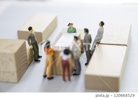 テーブルを囲んで話し合いをするミニチュアの人々 120668529